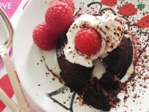 Molten chocolate cake topped with whipped cream and berries