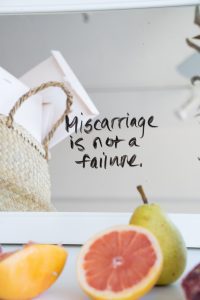 Image shows a quote written on a mirror: "Miscarriage is not a failure"