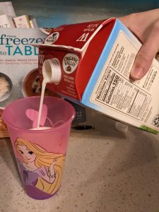 pouring Organic Valley Whole Milk into a kid's cup