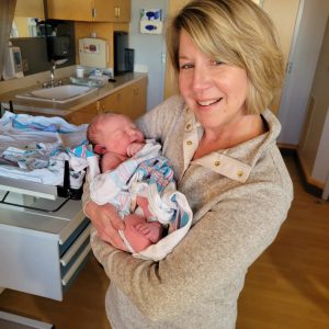 Woman holding first grandchild on the day he was born